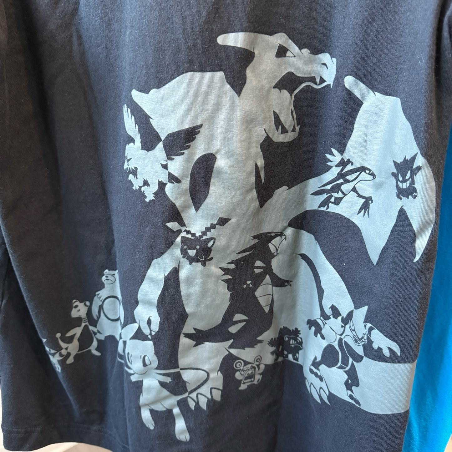 Upclose view of grey graphic of various Pokémon on black tshirt