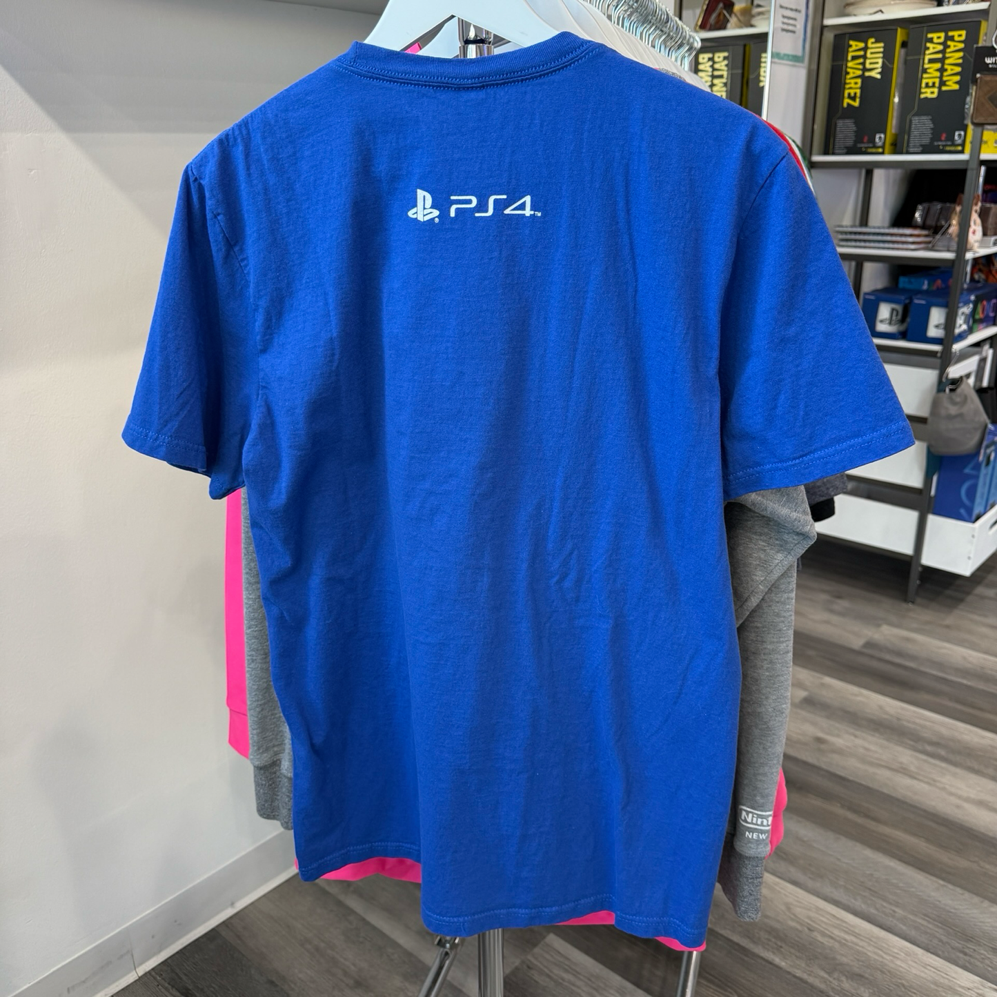 Back view of a blue tshirt with PS4 logo