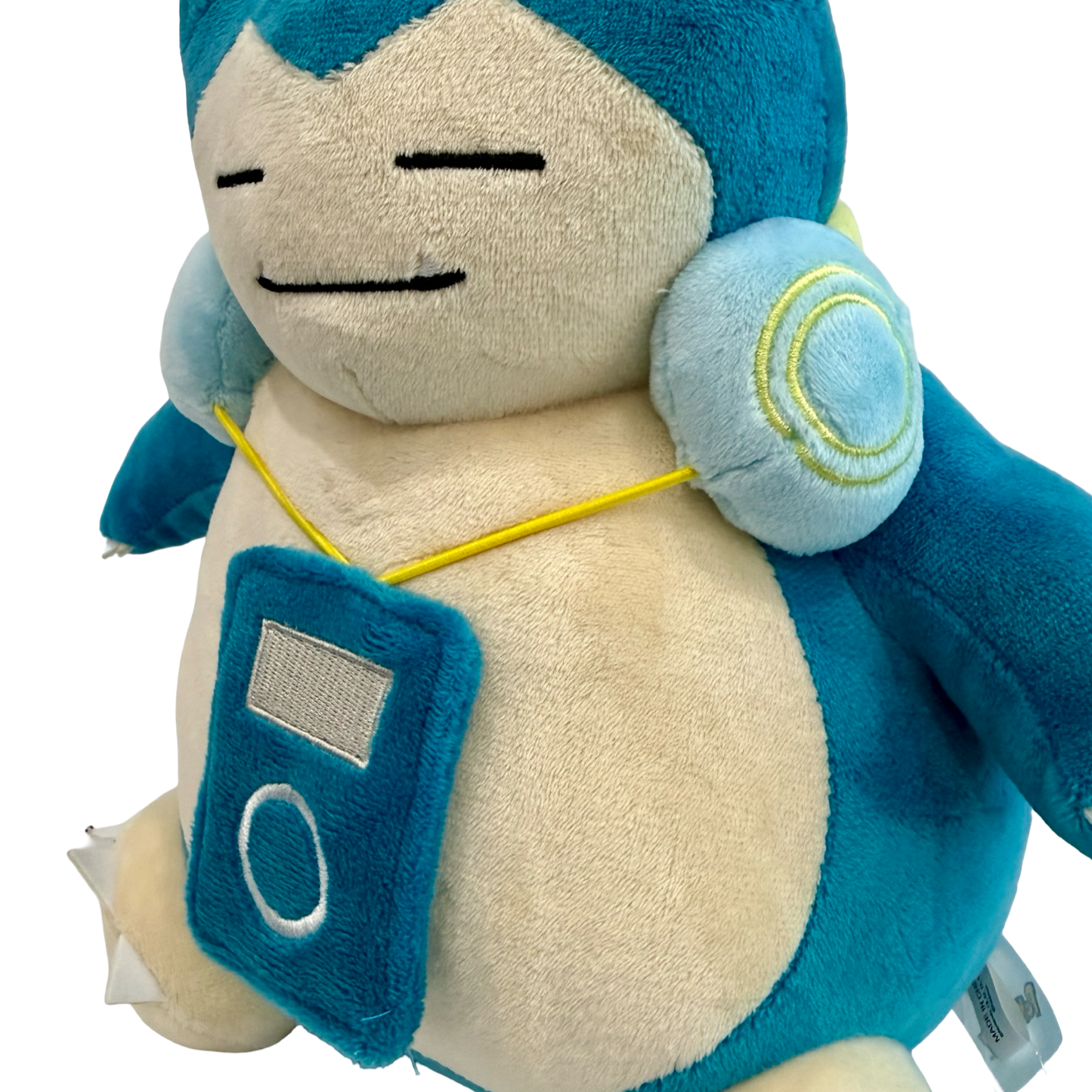 Plush Snorlax with headphones around his neck and music player hanging down.