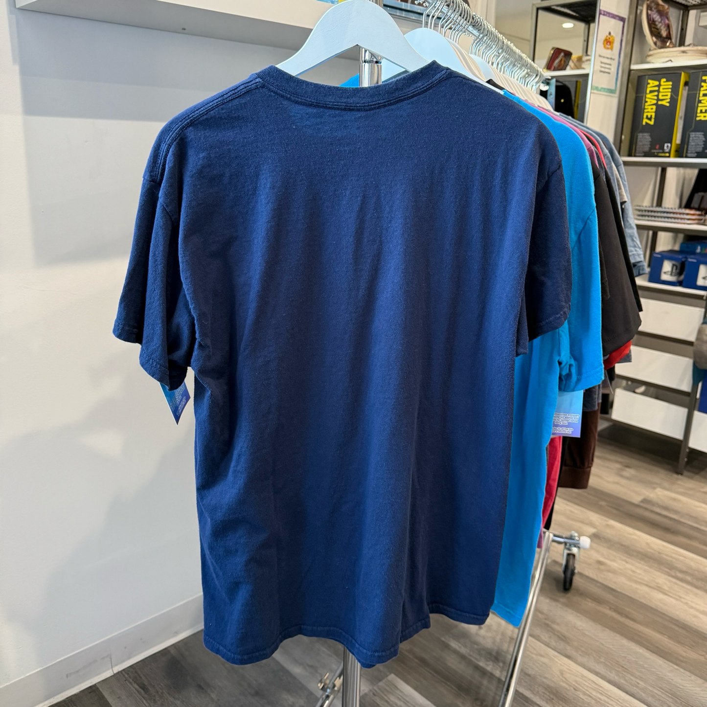 Back of navy blue tshirt hanging on a rack