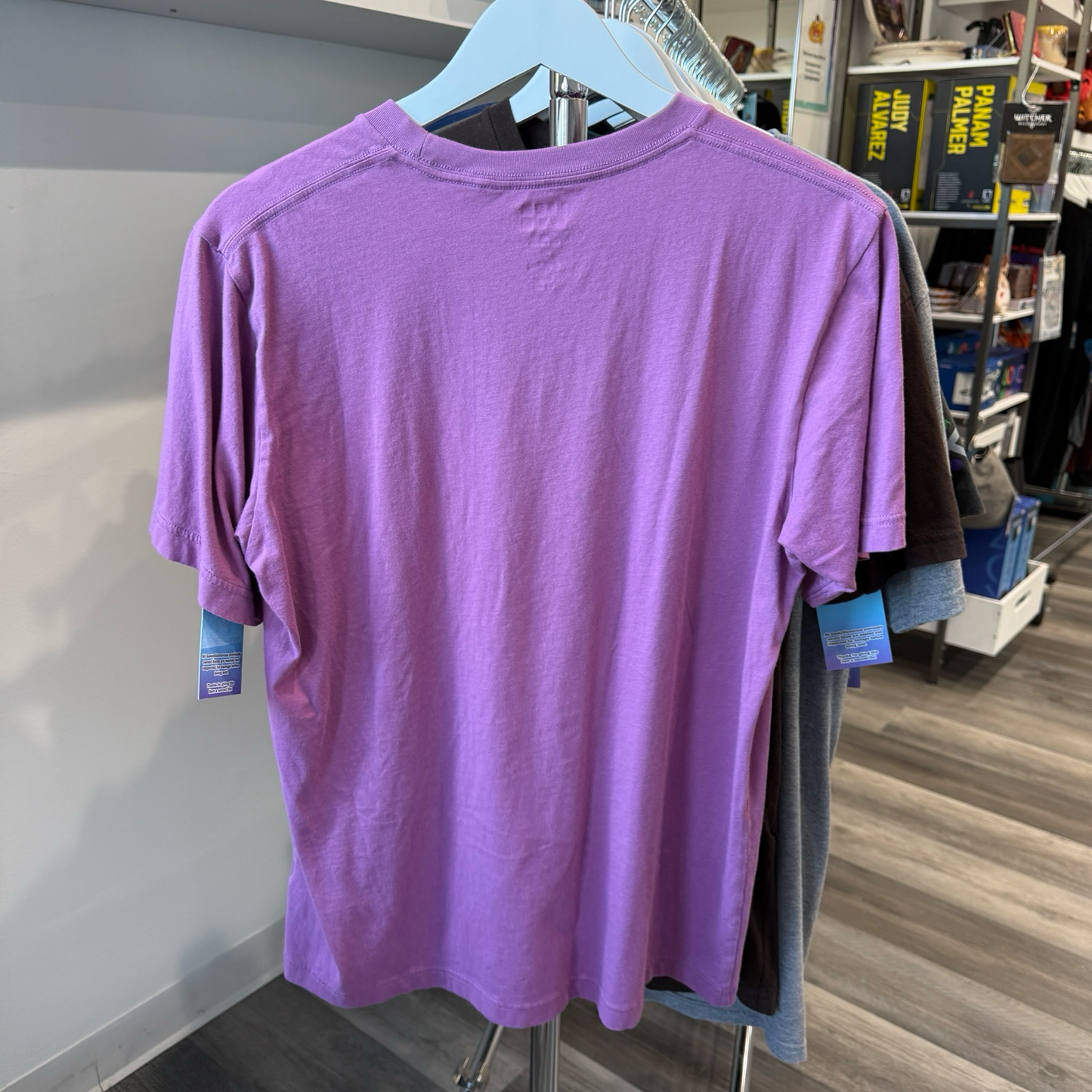Back view of purple shirt hanging in a store