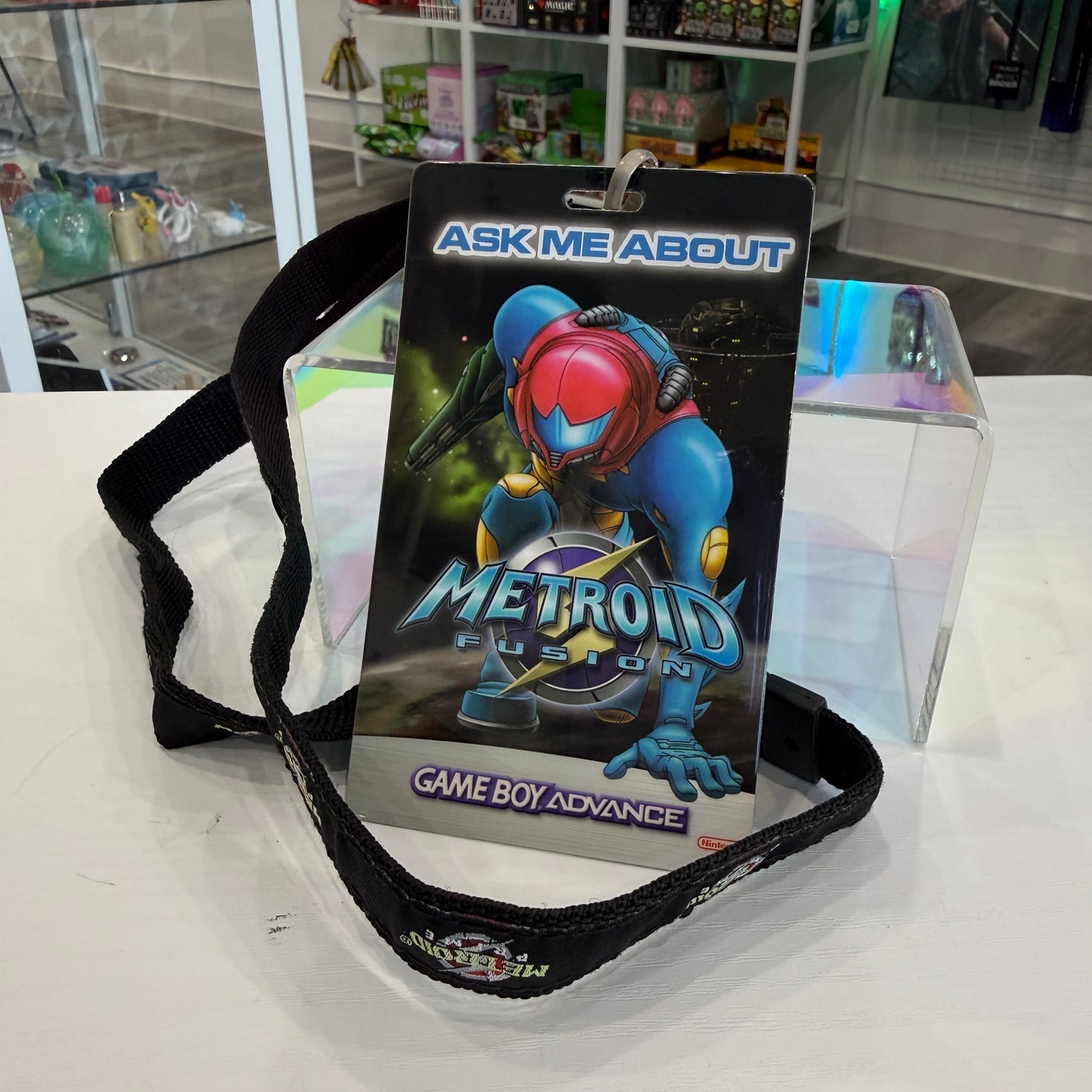 Metroid Fusion Game Boy Advance card with strap on a white surface