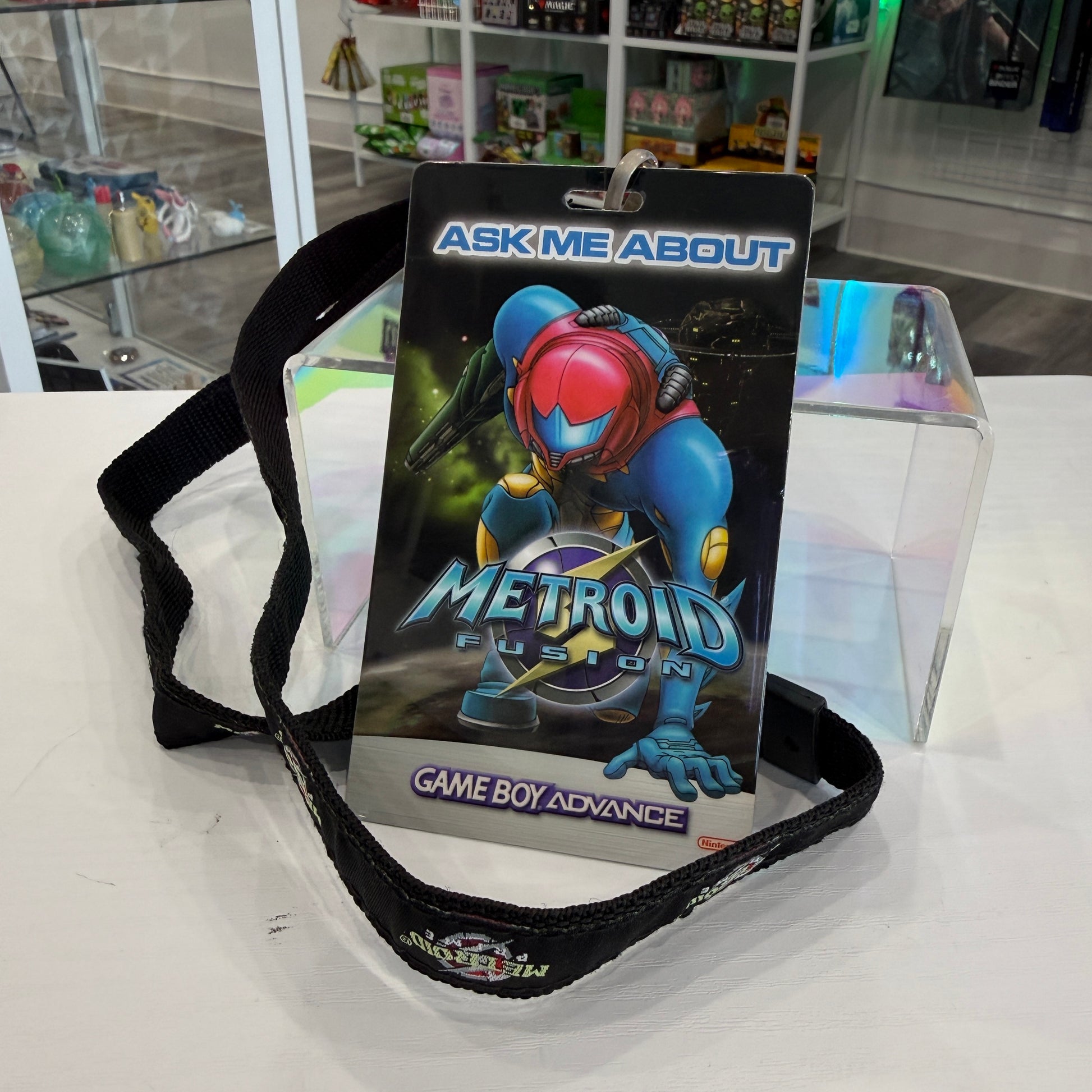 Metroid Fusion Game Boy Advance card with strap on a white surface