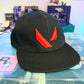 Black hat with red Valorant logo on a store counter 