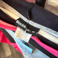 Black Clothing clothing tag that is cut, reads size Medium. 