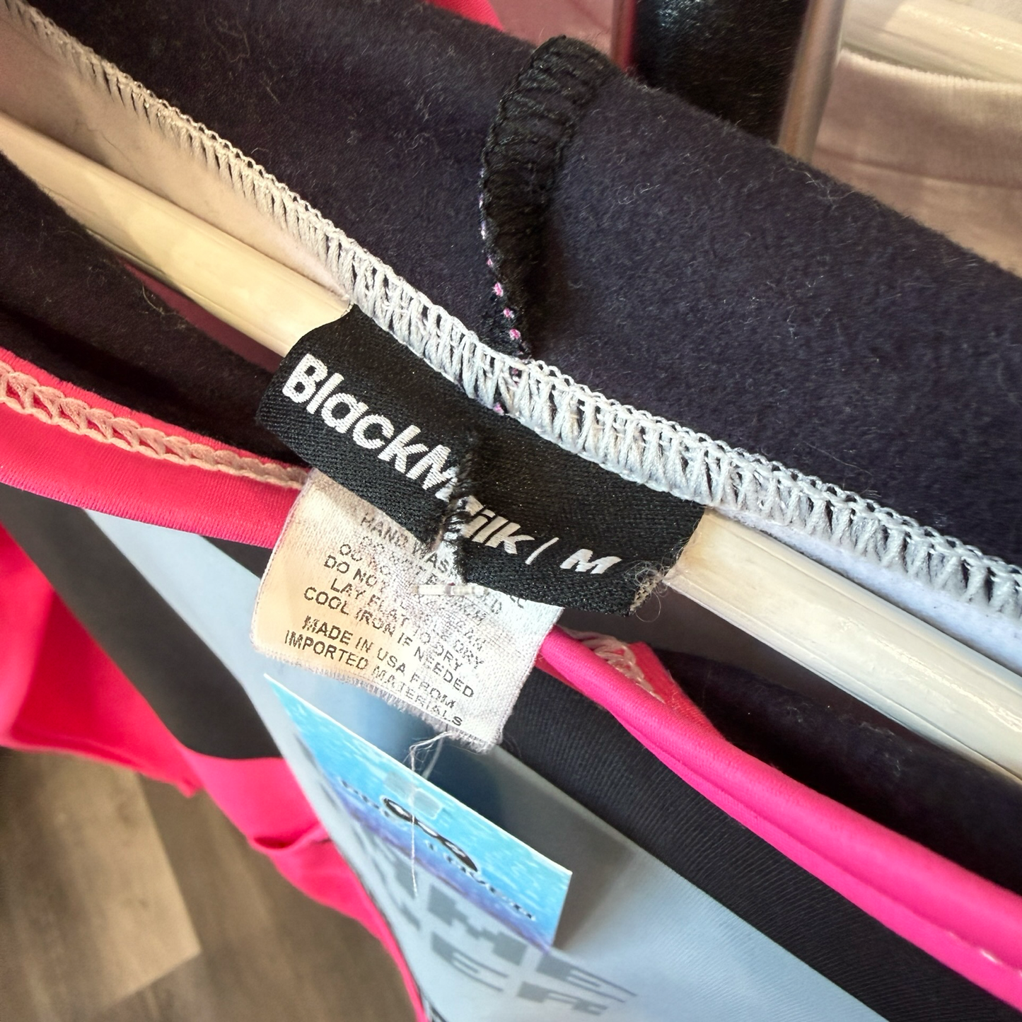 Black Clothing clothing tag that is cut, reads size Medium. 