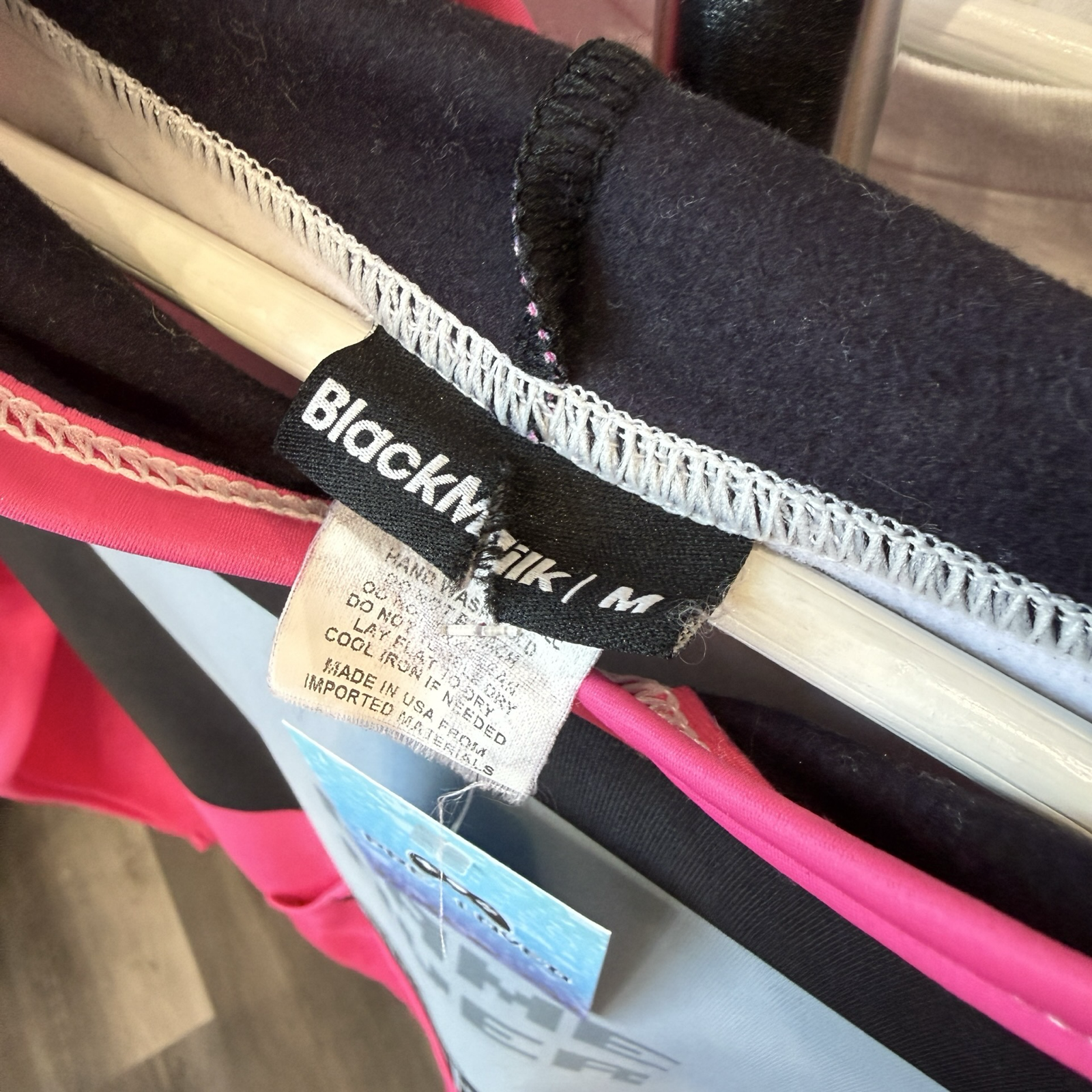 Black Clothing clothing tag that is cut, reads size Medium. 
