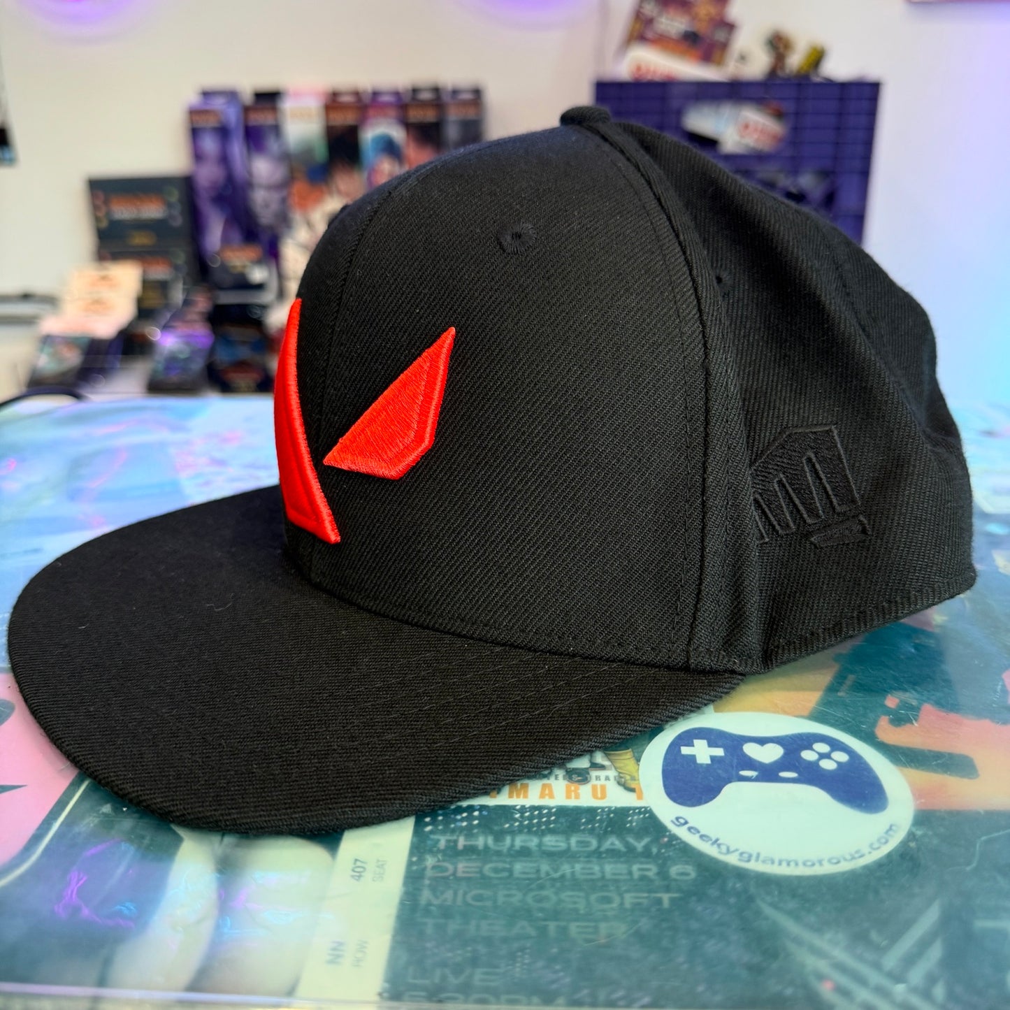 Black hat with red Valorant logo on a store counter 