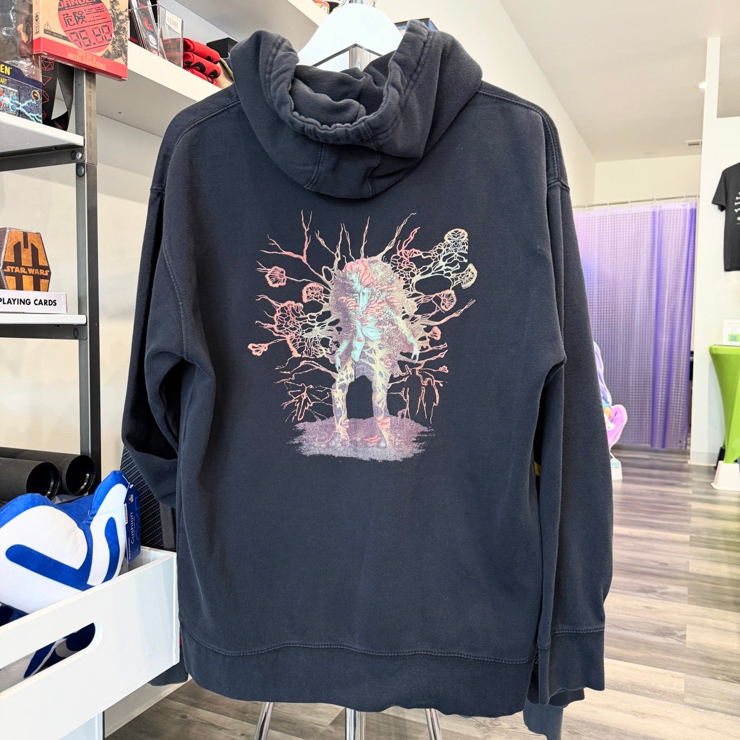 Black hoodie with Last of Us Infected graphic hanging in a store