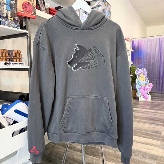 Grey hoodie with Jujutsu Kaisen wolf graphic on front in a store setting