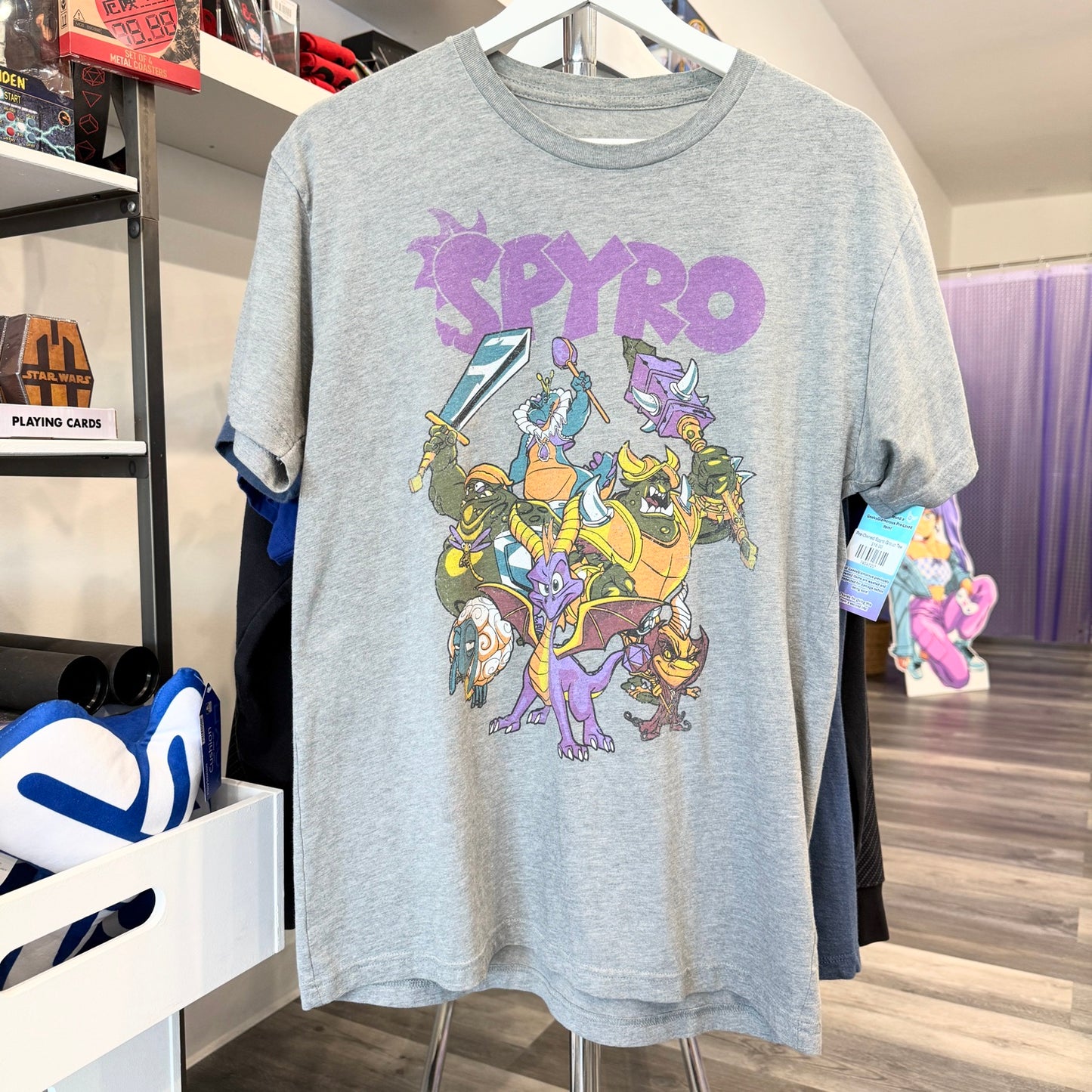 Gray t-shirt with 'Spyro' graphic design hanging on a rack in a store.