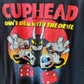 Close up shot of black tshirt with Cuphead Deal with the Devil graphic in red, yellow, and black. 