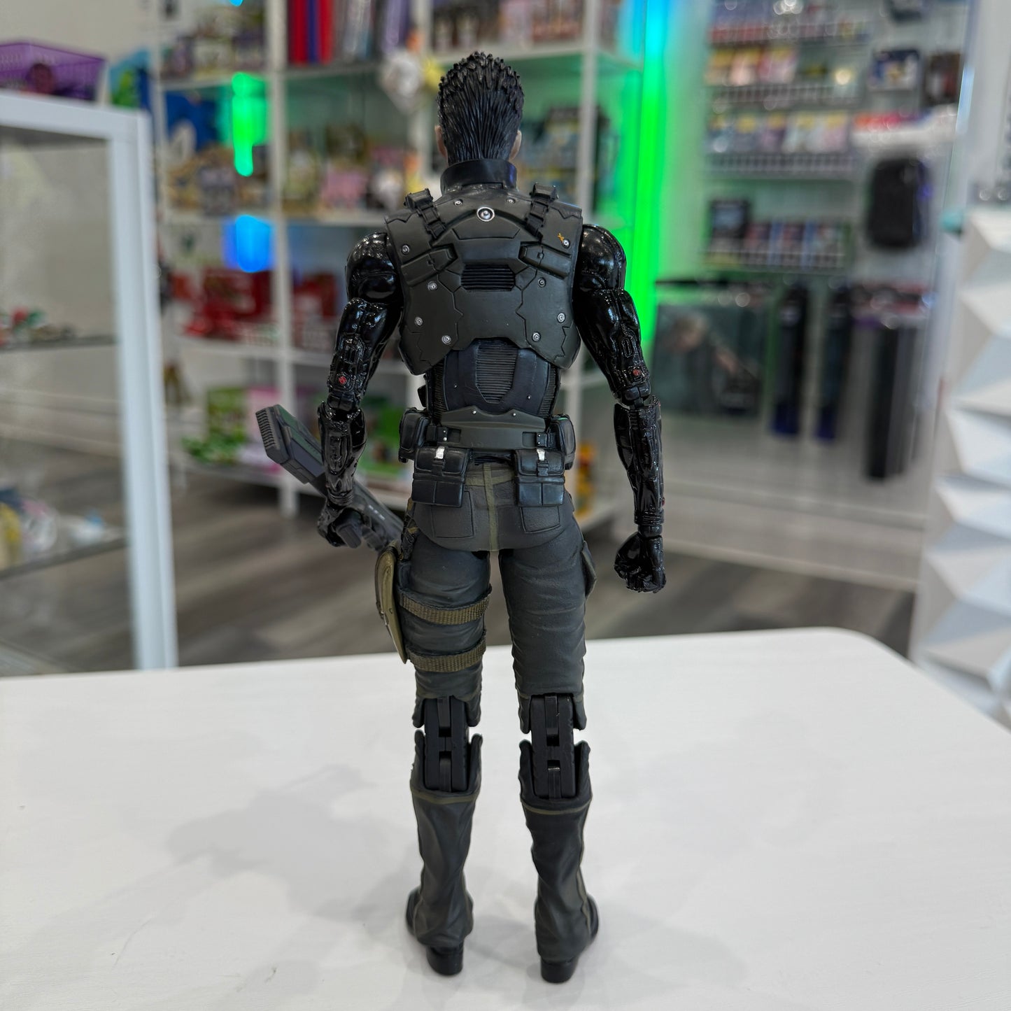 Action figure in a detailed costume standing on a white surface with a store shelf in the background.