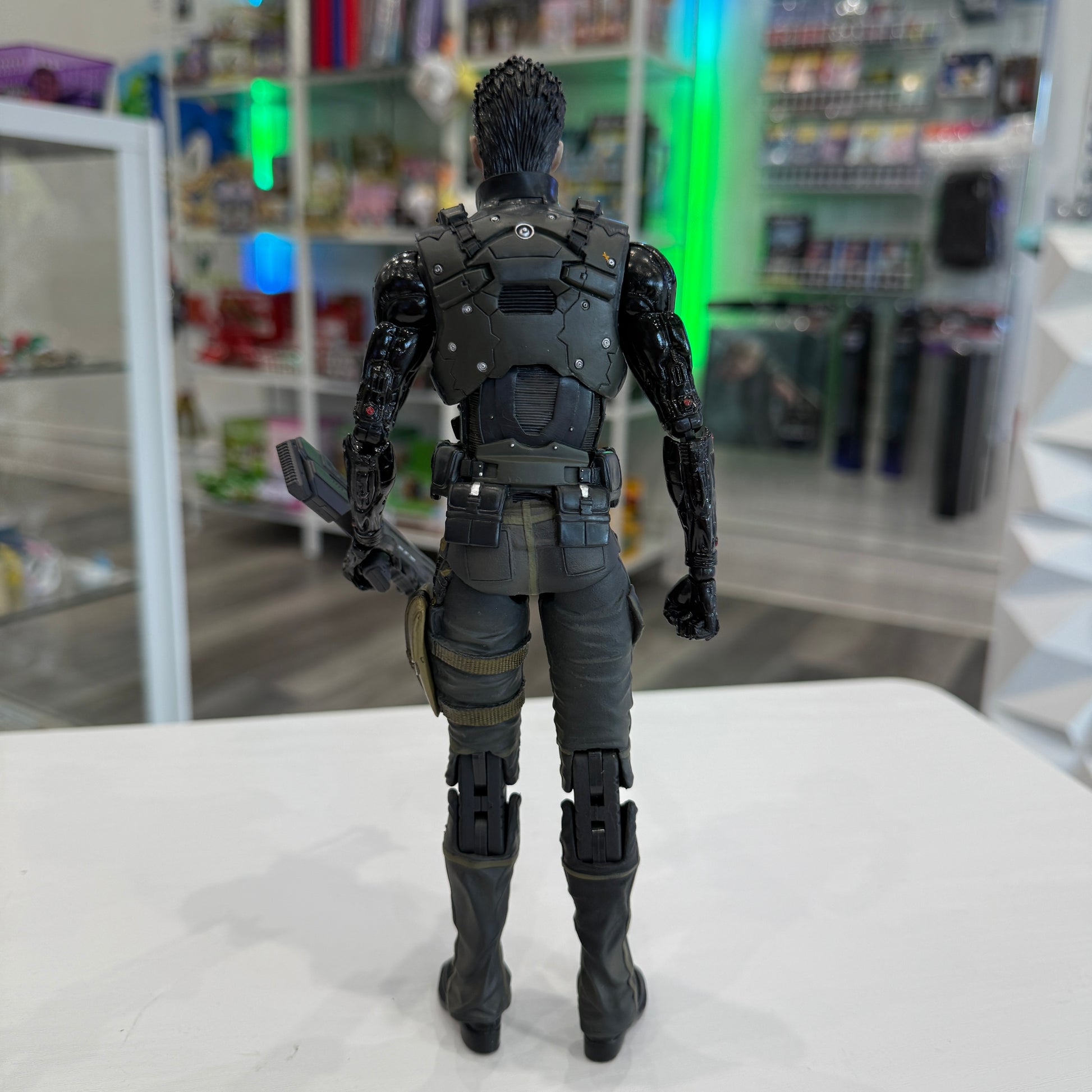 Action figure in a detailed costume standing on a white surface with a store shelf in the background.