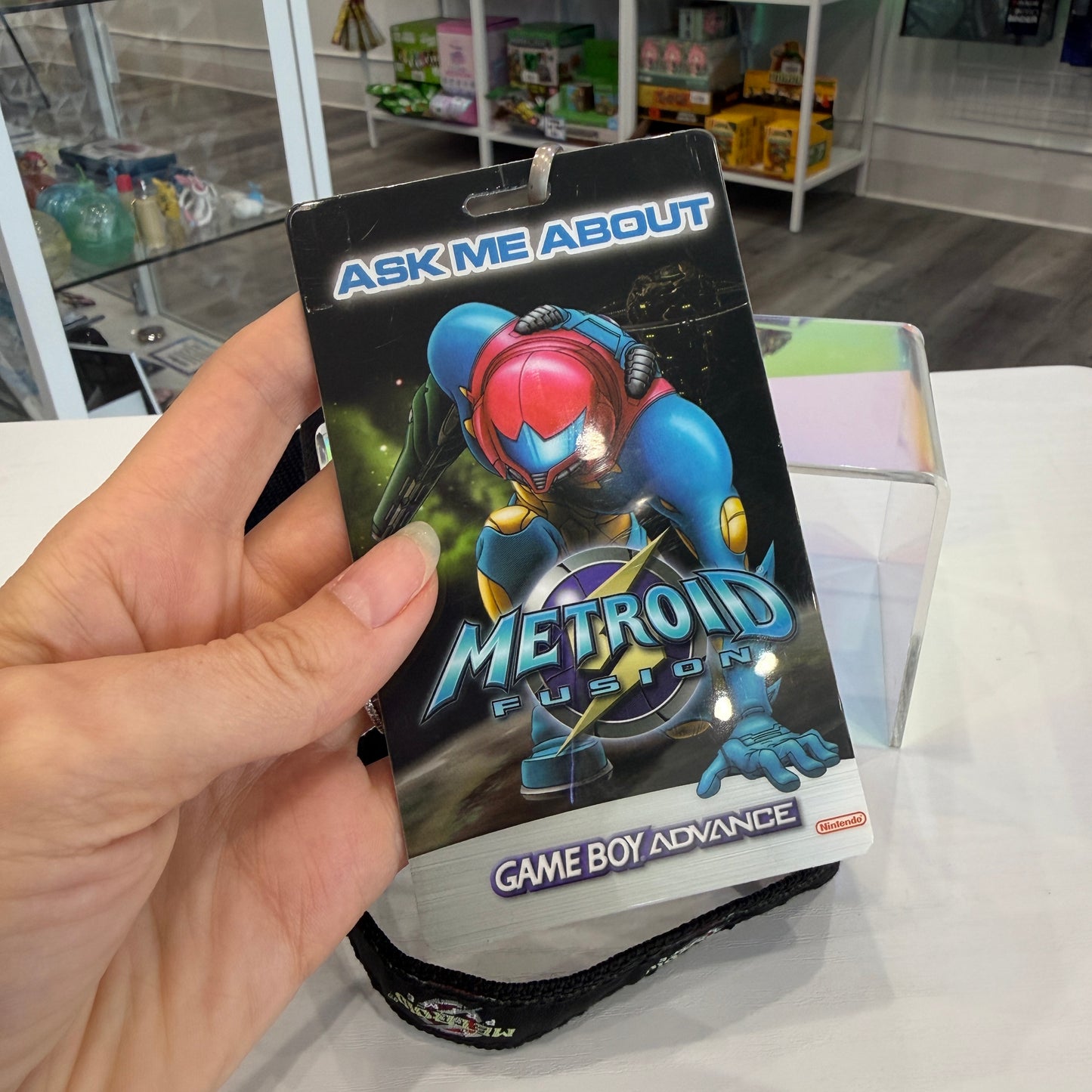 Hand holding a Metroid Fusion Game Boy Advance lanyard card.