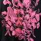 A close-up of a black garment featuring a vibrant hot pink graphic print of artwork of anime character Urusei Yatsura in a dense, overlapping collage.