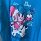 Close up shot of teal blue color tshirt with white and red graphic of boy sitting in a egg from video game, Billy Hatcher and the Giant Egg. 