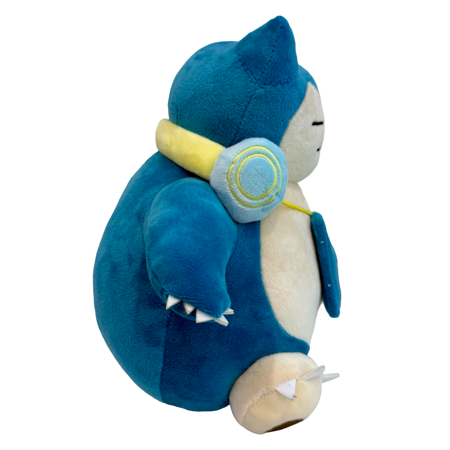 Plush Snorlax with headphones around his neck and music player hanging down. 