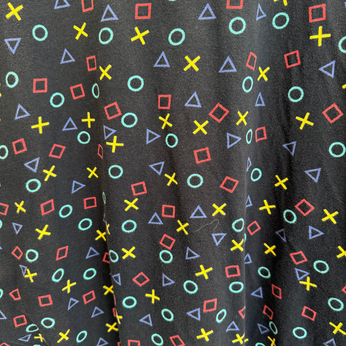 Close up shot of all-over pattern of PlayStation controller-style symbols (circles, squares, triangles, crosses)