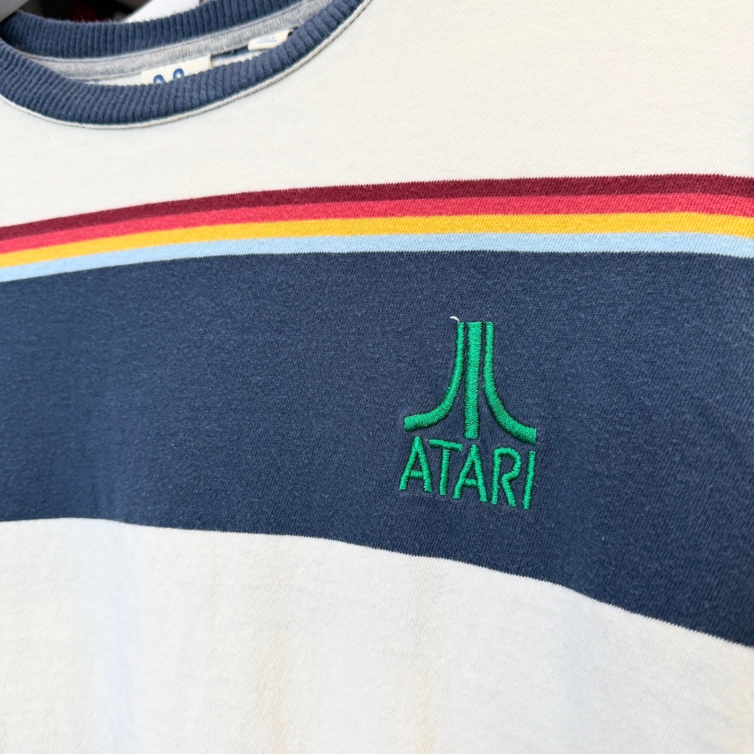 Close-up of a shirt with Atari logo and colorful stripes