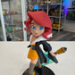 Animated character figurine with red hair and blue eyes, holding a weapon, in a store setting.
