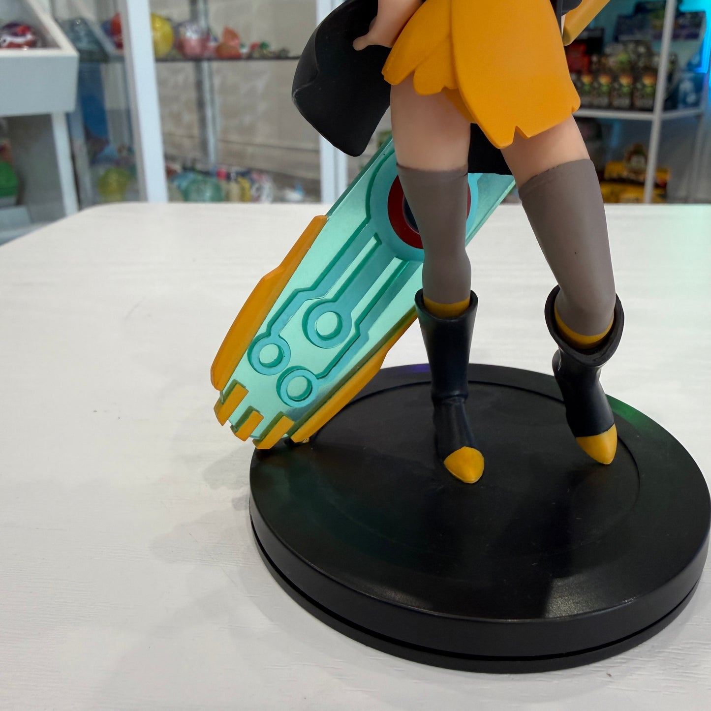 Red haired cartoon girl with futuristic sword on a black base with a shop in the background. 