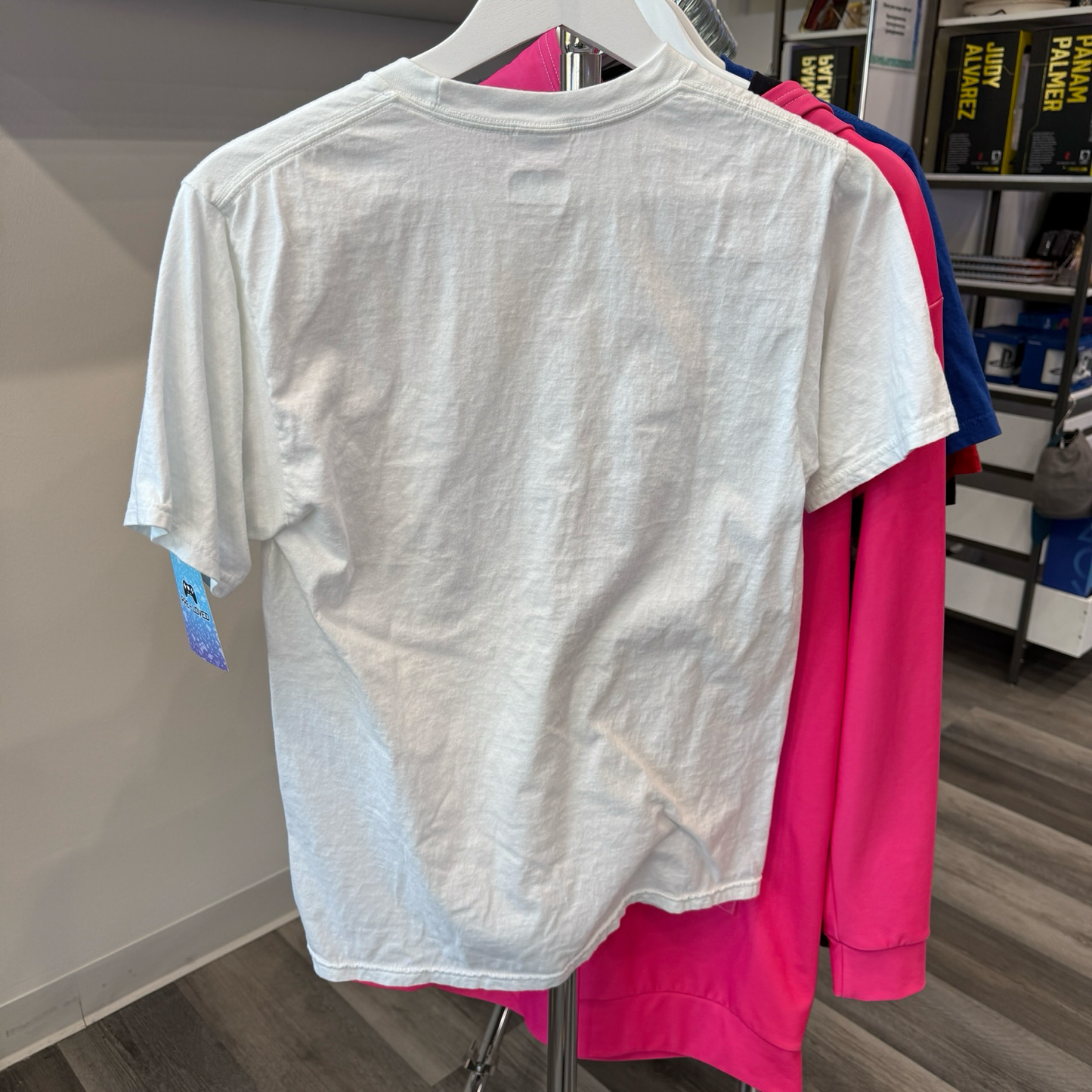 Back of white tshirt hanging on a rack