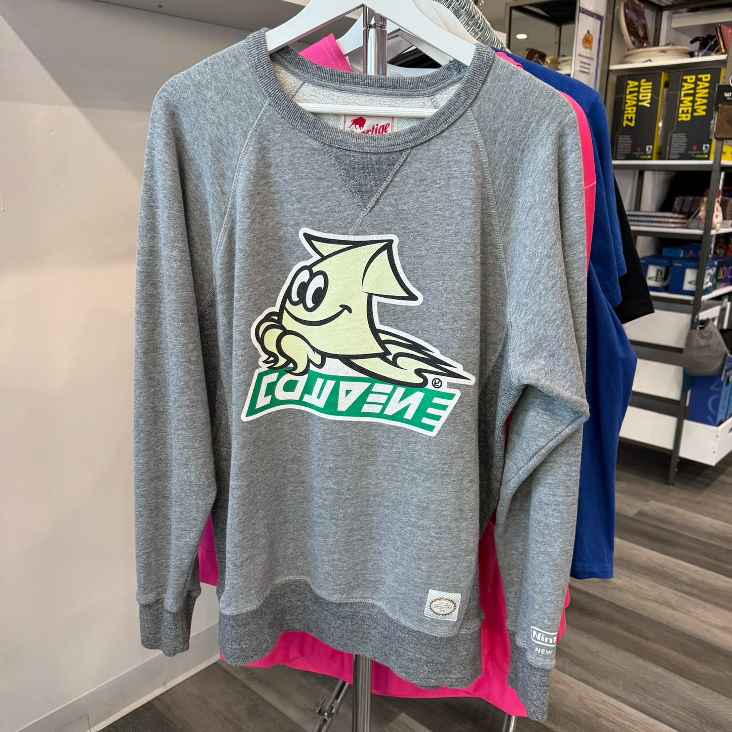 Grey pullover sweatshirt with cream color and green logo from the video game, Splaton. 