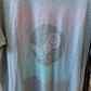 Upclose shot of heather grey tshirt with Steam logo done in pink, purple, and green ombre. 