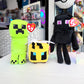 Three Minecraft plush toys from Ty brand, including a green Creeper, a yellow bee character, and a black Enderman, displayed on a white table with a blurred store background.