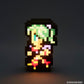 A pixel-art illuminated character figure stands against a dark gray background. The figure has green hair, a yellow face and torso, and red and purple accents, with a black blocky outline.