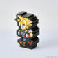 A pixel-art collectible figurine of Cloud Strife from Final Fantasy VII, constructed from black square blocks with yellow, blue, and red details, set against a clean light gray background. A copyright watermark for Square Enix is visible in the bottom right corner.