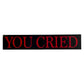 Red and black sticker with “you cried” text on a white background