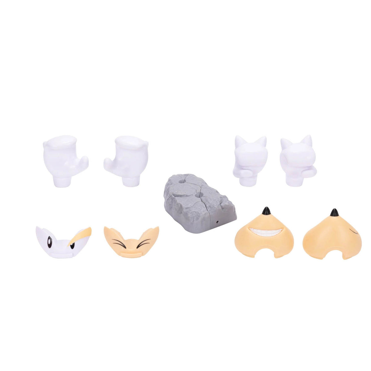 A set of small accessory pieces arranged on a plain white background, including several white claw-like pieces, two tan fox-like faces, a gray rock-shaped piece, and two peach-colored curved pieces with black tips.
