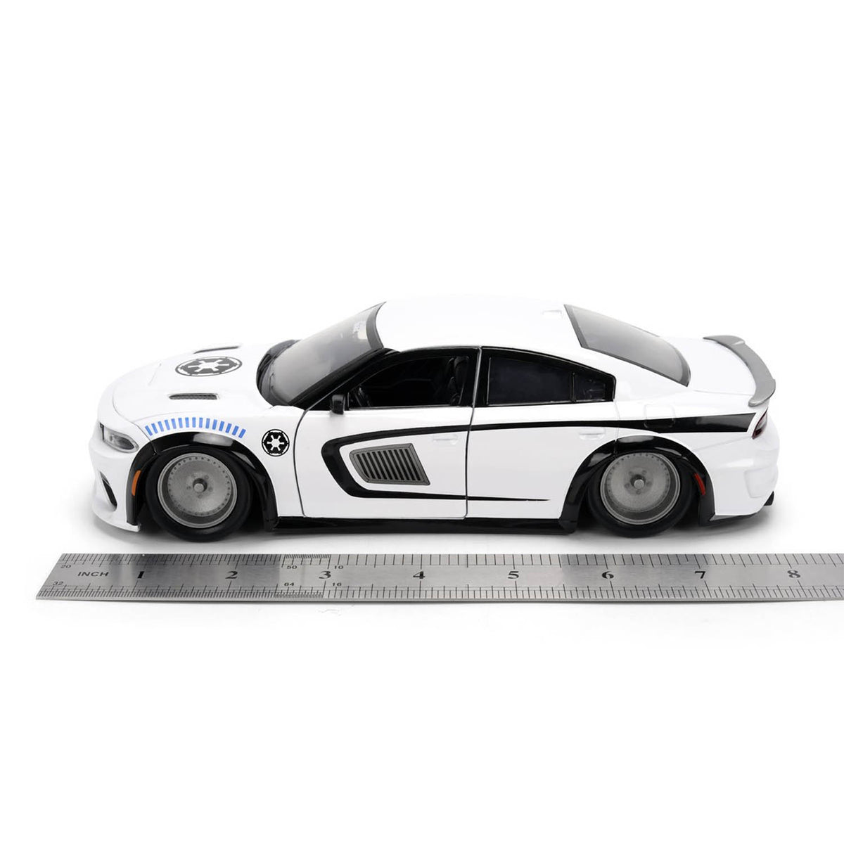 White model car with black accents on a white background, accompanied by a ruler for scale showing 8" long.